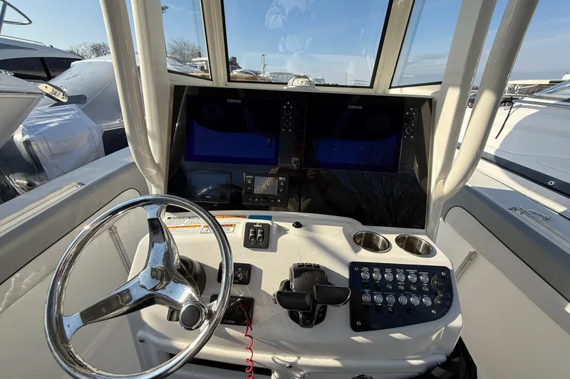 Slide: The Image of 2021 NauticStar 28 XS boat helm with dual Simrad displays and steering wheel. - 12