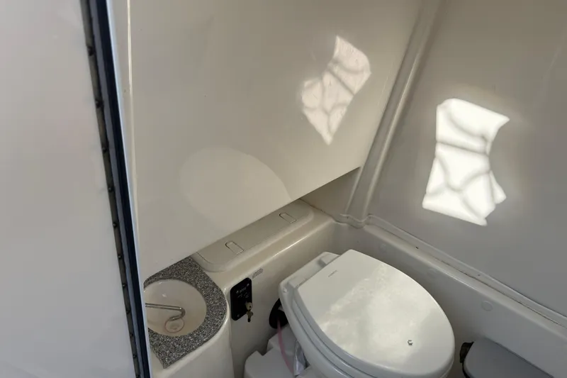 Slide: The Image of 2021 NauticStar 28 XS boat interior bathroom with toilet and sink. - 13
