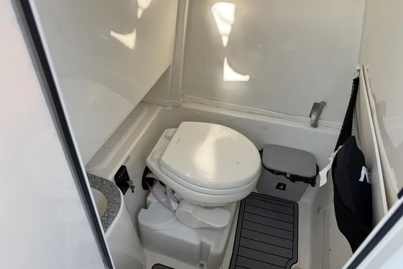Slide: The Image of 2021 NauticStar 28 XS boat interior bathroom with toilet and storage. - 14