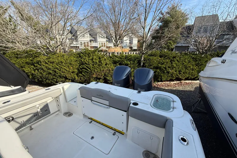 Slide: The Image of 2021 NauticStar 28 XS boat with dual engines, parked near residential area. - 21