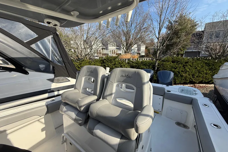 Slide: The Image of 2021 NauticStar 28 XS boat interior with dual captain's chairs and outdoor setting. - 22