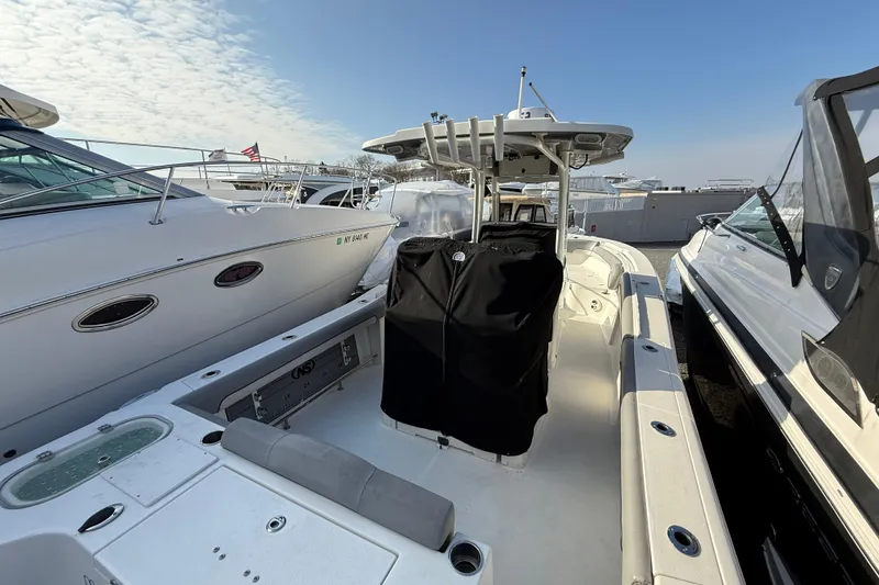 Slide: The Image of 2021 NauticStar 28 XS boat docked between other vessels under a clear sky. - 23
