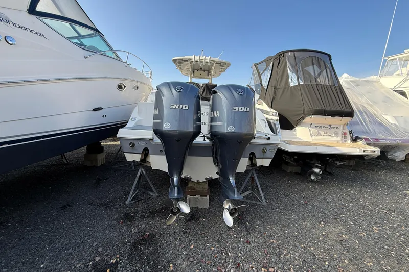 Slide: The Image of 2021 NauticStar 28 XS boat with twin Yamaha 300 engines, docked on gravel. - 25