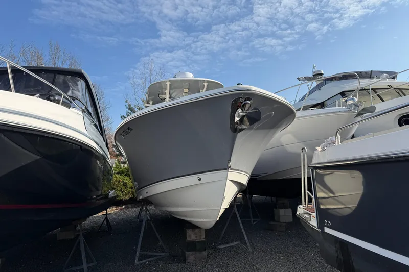 Slide: The Image of 2021 NauticStar 28 XS boat on stands, surrounded by other vessels, under a clear sky. - 29