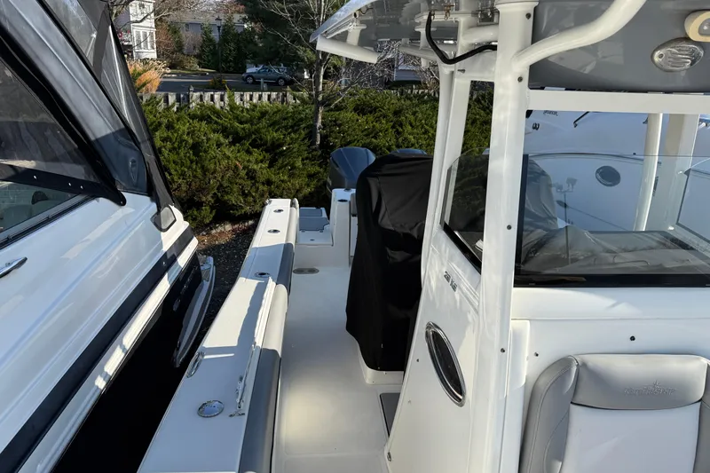 Slide: The Image of 2021 NauticStar 28 XS boat interior with seating and console, docked outdoors. - 6