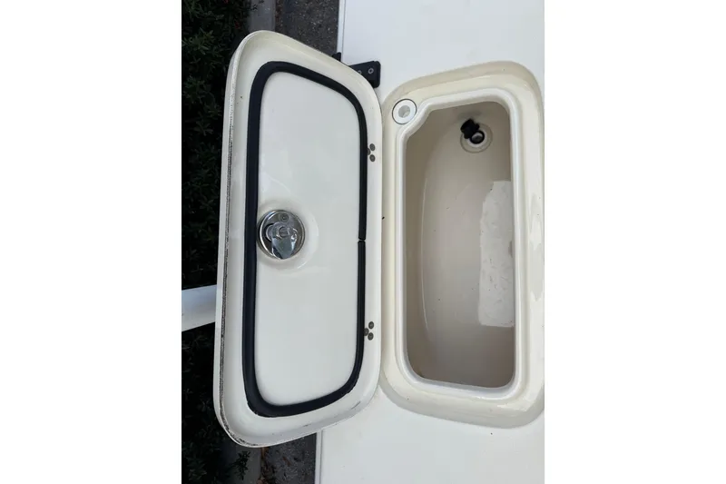 Slide: The Image of Open storage compartment on a 2006 Scout 170 Costa boat, featuring a secure latch. - 13