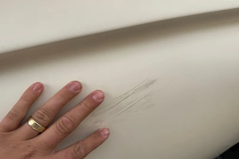 Slide: The Image of Hand touching scratched surface of 2006 Scout 170 Costa boat. - 26