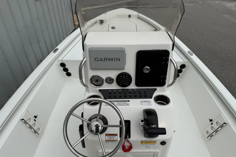 Slide: The Image of 2026 Avid 19 FSX boat console with Garmin navigation, steering wheel, and controls. - 10