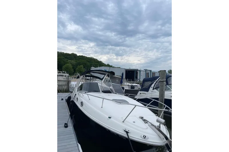 Slide: The Image of 2006 Sea Ray 260 Sundancer docked at marina under cloudy sky. - 24