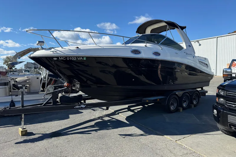 Slide: The Image of 2006 Sea Ray 260 Sundancer boat on trailer, parked outdoors under clear blue sky. - 25