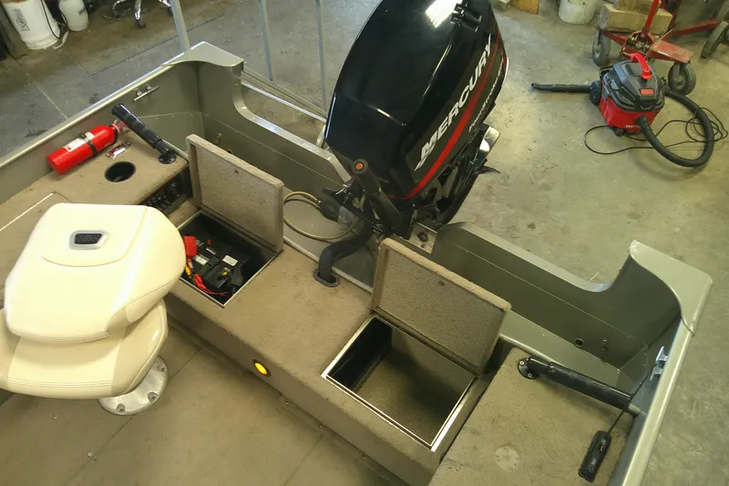 Slide: The Image of 2003 Lund 1650 Explorer Tiller boat interior with Mercury engine and storage compartments. - 9