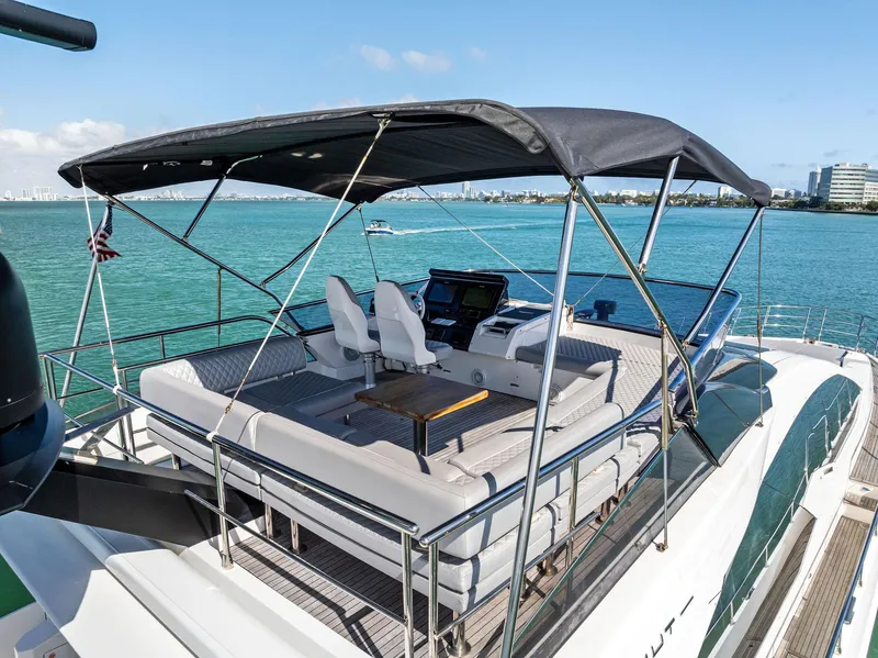 Slide: The Image of 2017 Azimut 77S yacht flybridge with seating, helm, and canopy on turquoise water. - 41