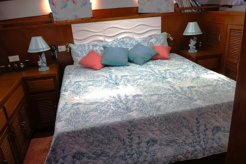 Slide: The Image of 1988 Sea Ranger 46 Sundeck Trawler bedroom with nautical-themed bedding and decor. - 12