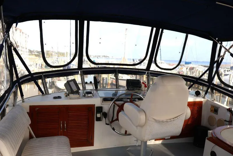 Slide: The Image of Interior view of 1988 Sea Ranger 46 Sundeck Trawler helm with marina backdrop. - 19