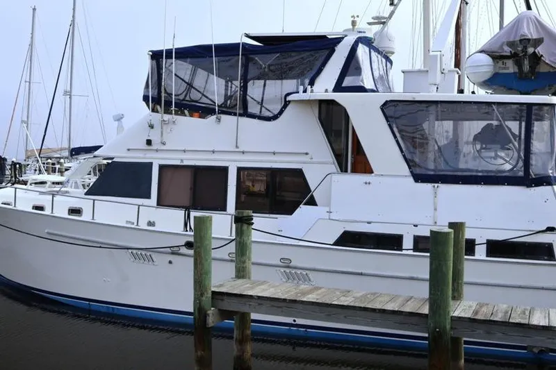 Slide: The Image of 1988 Sea Ranger 46 Sundeck Trawler docked at marina, featuring spacious upper deck. - 2