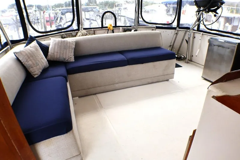 Slide: The Image of 1988 Sea Ranger 46 Sundeck Trawler interior with blue cushioned seating and large windows. - 21