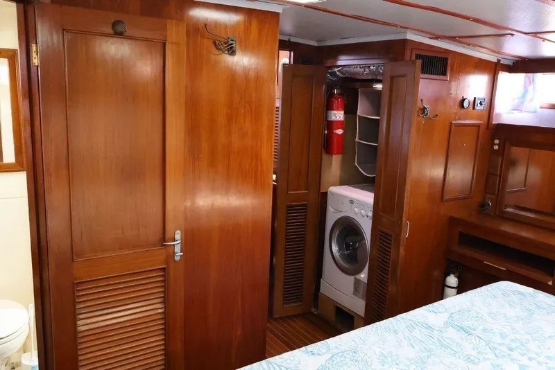 Slide: The Image of 1988 Sea Ranger 46 Sundeck Trawler interior with wood paneling, washer, and fire extinguisher. - 23