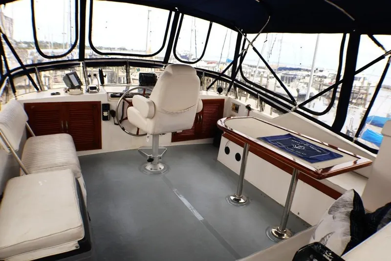 Slide: The Image of 1988 Sea Ranger 46 Sundeck Trawler helm with seating, steering wheel, and navigation equipment. - 6