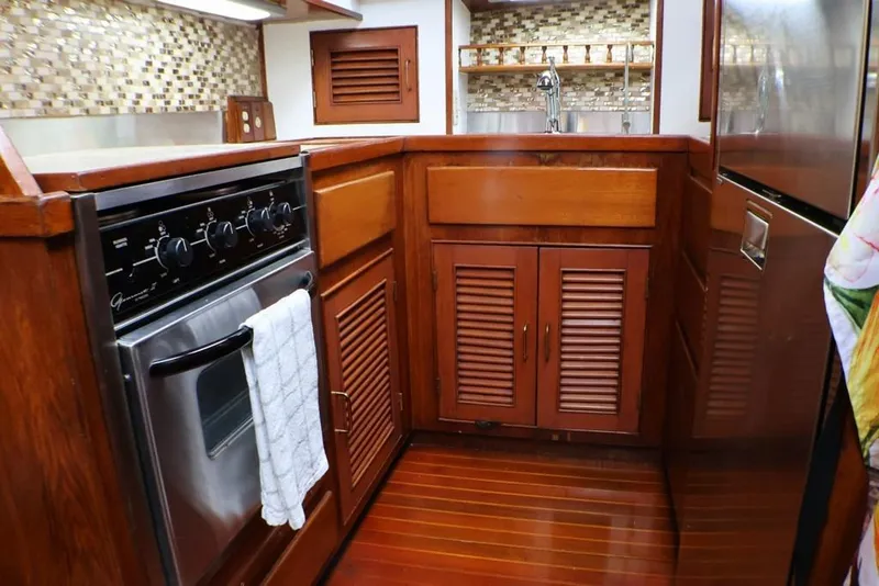 Slide: The Image of 1988 Sea Ranger 46 Sundeck Trawler kitchen with wood cabinetry and stainless steel oven. - 8