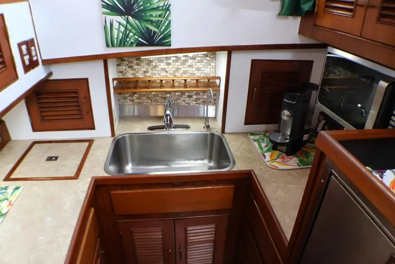 Slide: The Image of 1988 Sea Ranger 46 Sundeck Trawler kitchen with sink, coffee maker, and wooden cabinetry. - 9