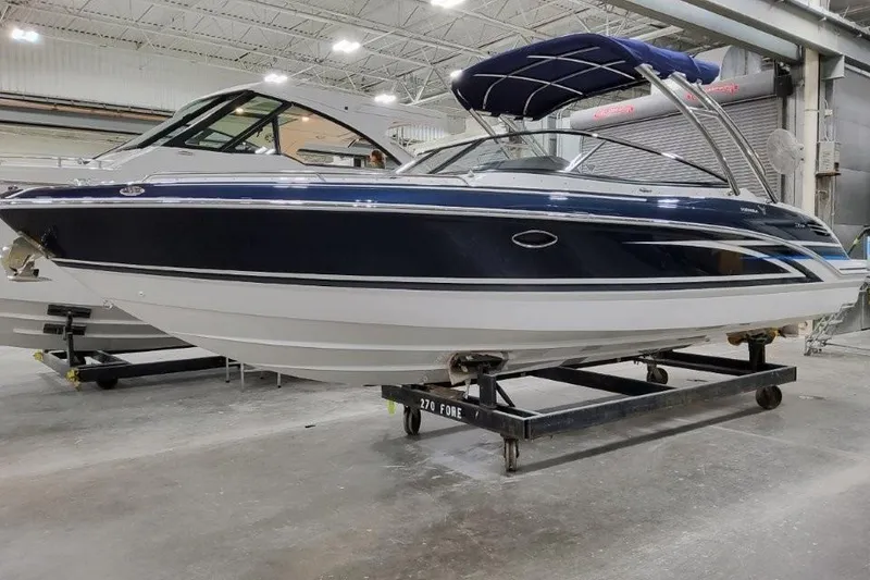 The Image of 2026 Formula 270 Bowrider boat in showroom, featuring sleek design and blue canopy. - 1