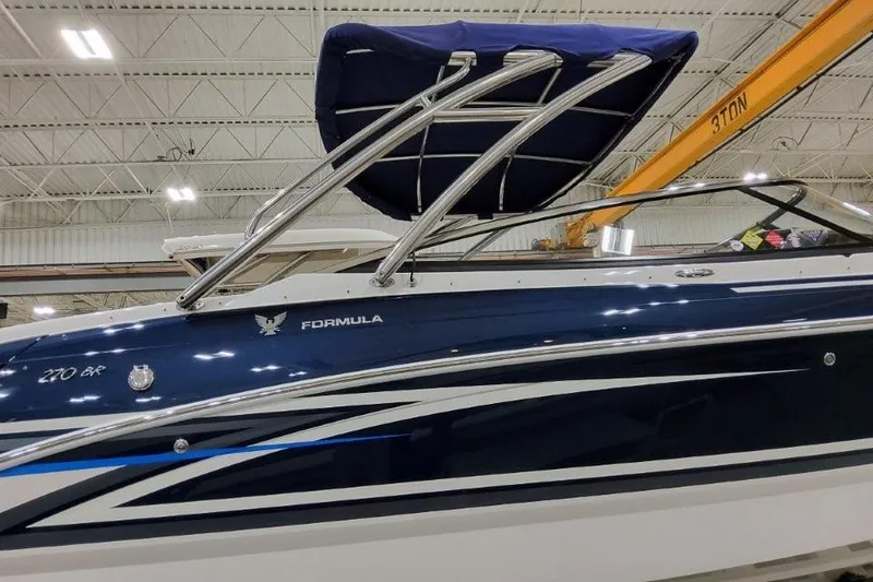 Slide: The Image of 2026 Formula 270 Bowrider boat with sleek blue design in indoor showroom. - 6