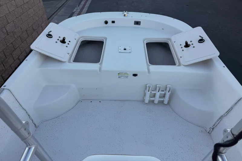 Slide: The Image of 2013 Carolina Skiff 218 boat interior with storage compartments and rod holders. - 10