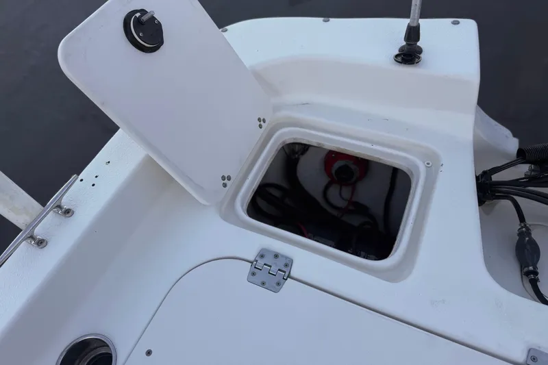 Slide: The Image of 2013 Carolina Skiff 218 boat compartment with open hatch and visible wiring. - 19