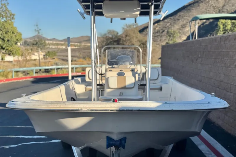 Slide: The Image of 2013 Carolina Skiff 218 boat parked outdoors with scenic mountain backdrop. - 2