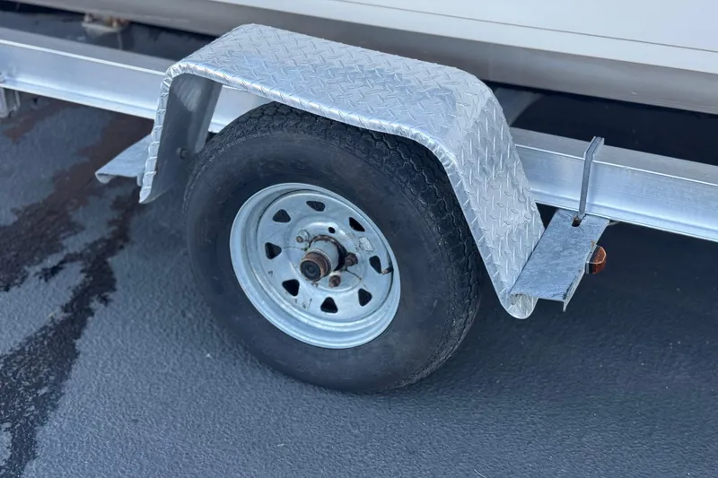 Slide: The Image of Trailer wheel and fender of a 2013 Carolina Skiff 218 boat. - 28