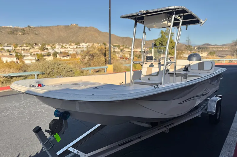 Slide: The Image of 2013 Carolina Skiff 218 boat on trailer, scenic background with hills and houses. - 3