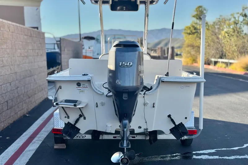 Slide: The Image of 2013 Carolina Skiff 218 boat with 150 horsepower outboard motor, parked on a sunny day. - 4