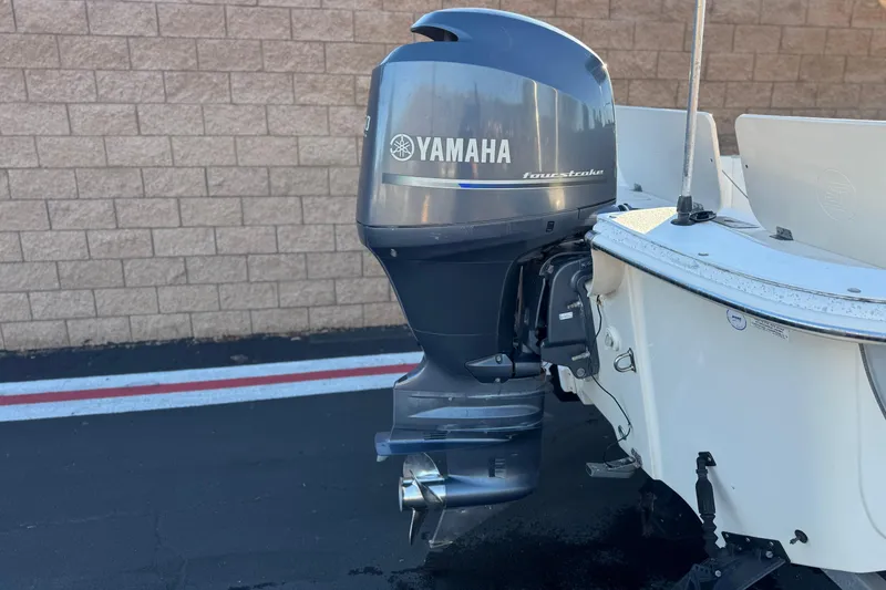 Slide: The Image of 2013 Carolina Skiff 218 with Yamaha four-stroke outboard motor, parked on pavement. - 6