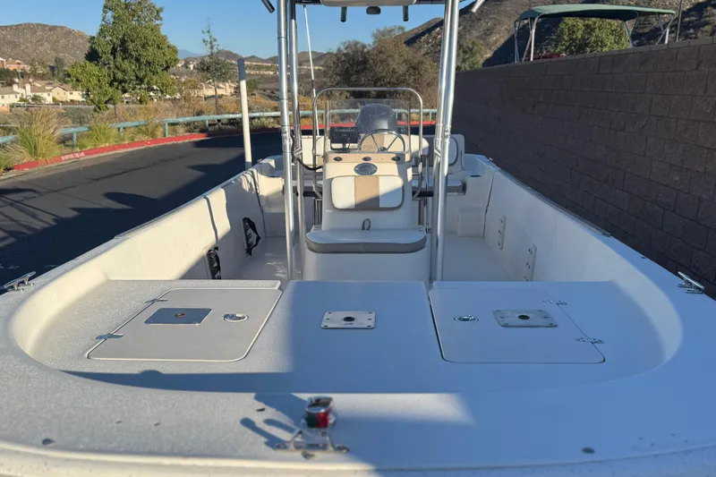 Slide: The Image of 2013 Carolina Skiff 218 boat, spacious deck, clear sky, scenic background. - 8