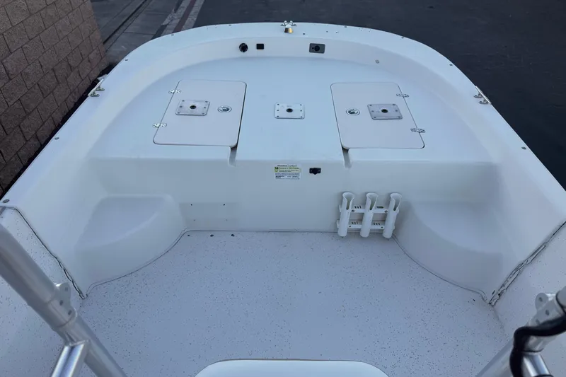 Slide: The Image of 2013 Carolina Skiff 218 boat deck with storage compartments and rod holders. - 9