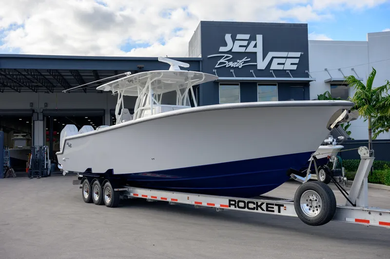Slide: The Image of 2025 SeaVee 400Z boat on trailer outside SeaVee facility under cloudy sky. - 10