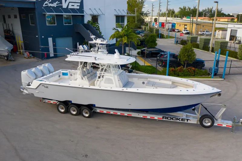 Slide: The Image of 2025 SeaVee 400Z boat on trailer, featuring triple Mercury engines, parked in a marina. - 7