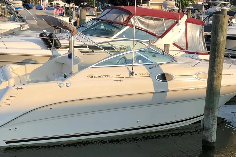 The Image of 2000 Sea Ray 240 Sundancer boat docked in a marina, side view. - 0