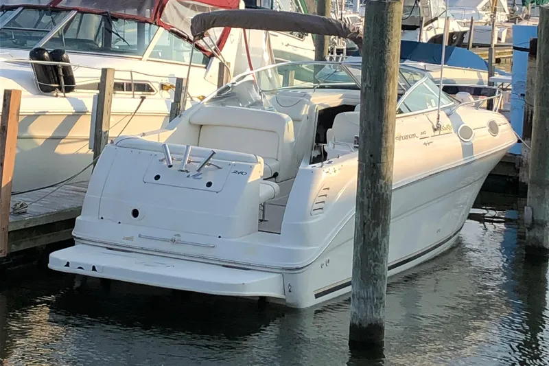 Slide: The Image of 2000 Sea Ray 240 Sundancer docked at marina, white exterior, sunny day. - 1