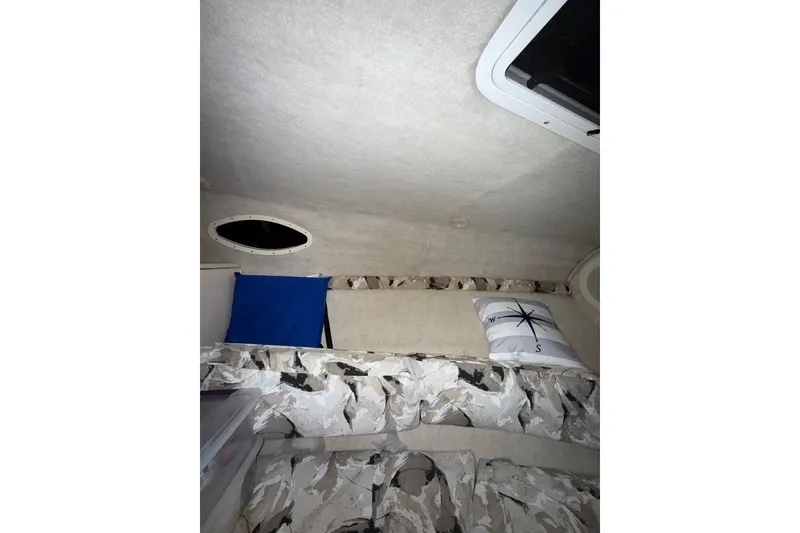 Slide: The Image of Interior cabin of 2000 Sea Ray 240 Sundancer boat, featuring seating and storage. - 13