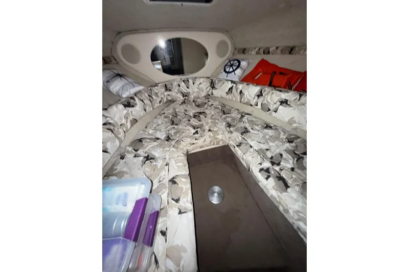 Slide: The Image of Interior cabin of 2000 Sea Ray 240 Sundancer with cushions and porthole. - 15