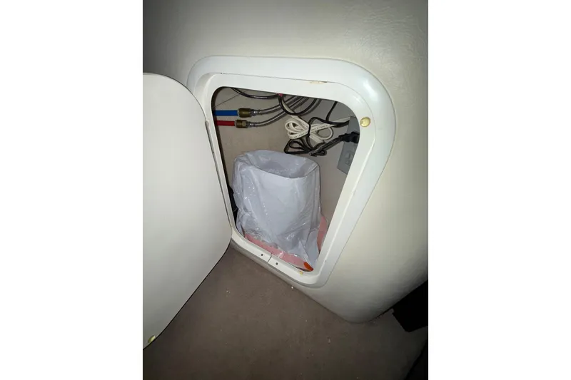 Slide: The Image of Storage compartment in 2000 Sea Ray 240 Sundancer boat, with beige upholstery. - 17