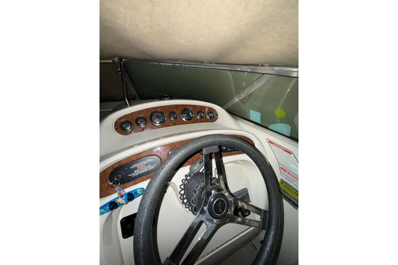 Slide: The Image of Interior seating of 2000 Sea Ray 240 Sundancer boat, featuring white upholstery and speaker. - 22