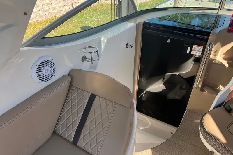 Slide: The Image of 2018 Sea Ray Sundancer 280 interior with seating, speaker, and cabin entrance. - 11
