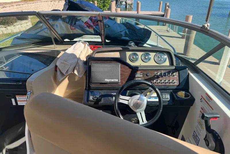 Slide: The Image of 2018 Sea Ray Sundancer 280 helm with steering wheel, gauges, and Raymarine navigation system. - 13
