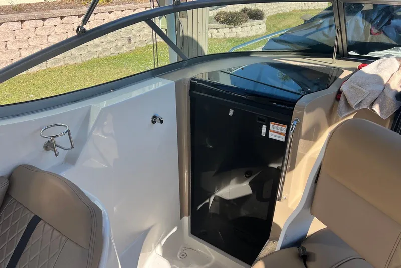 Slide: The Image of Interior of a 2018 Sea Ray Sundancer 280 boat, featuring seating and a small fridge. - 14