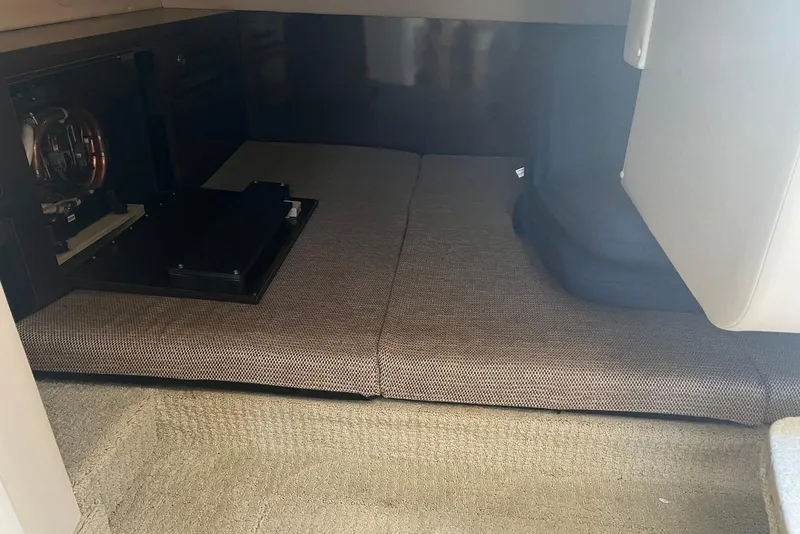 Slide: The Image of Interior cabin of 2018 Sea Ray Sundancer 280, featuring cushioned seating and storage area. - 18