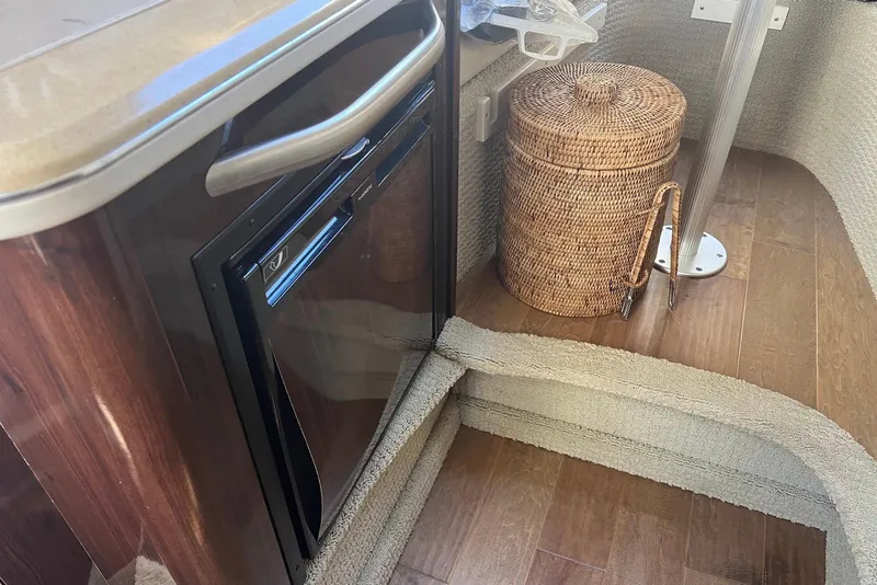 Slide: The Image of Interior of 2018 Sea Ray Sundancer 280 with fridge and wicker basket. - 28