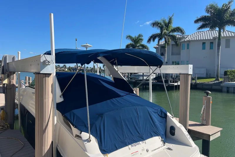 Slide: The Image of 2018 Sea Ray Sundancer 280 docked with blue canopy, palm trees in background. - 6