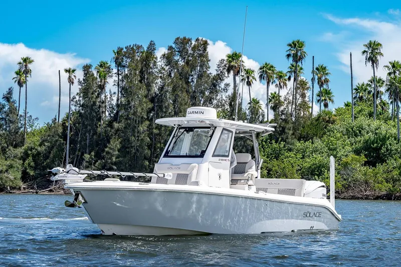 Slide: The Image of Manufacturer Provided Image: 2026 Solace 28 HCS boat cruising on a scenic waterway with lush greenery. - 4